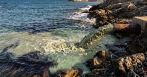 Sversamento di acque reflue e inquinanti in mare da un tubo sulla costa.