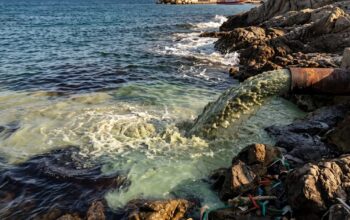 Sversamento di acque reflue e inquinanti in mare da un tubo sulla costa.