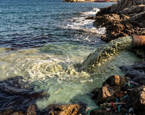 Sversamento di acque reflue e inquinanti in mare da un tubo sulla costa.