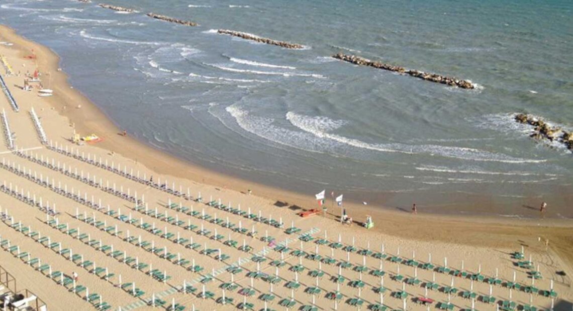 Veduta aerea della spiaggia di Termoli a settembre con lettini ordinati e bagnanti in mare.