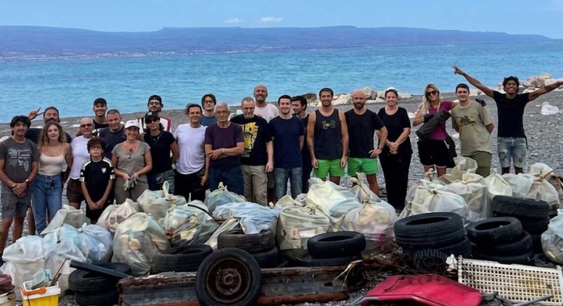 I volontari della pulizia spiagge a Messina in posa davanti ai sacchi di rifiuti e copertoni raccolti