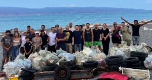 I volontari della pulizia spiagge a Messina in posa davanti ai sacchi di rifiuti e copertoni raccolti