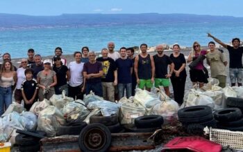 I volontari della pulizia spiagge a Messina in posa davanti ai sacchi di rifiuti e copertoni raccolti