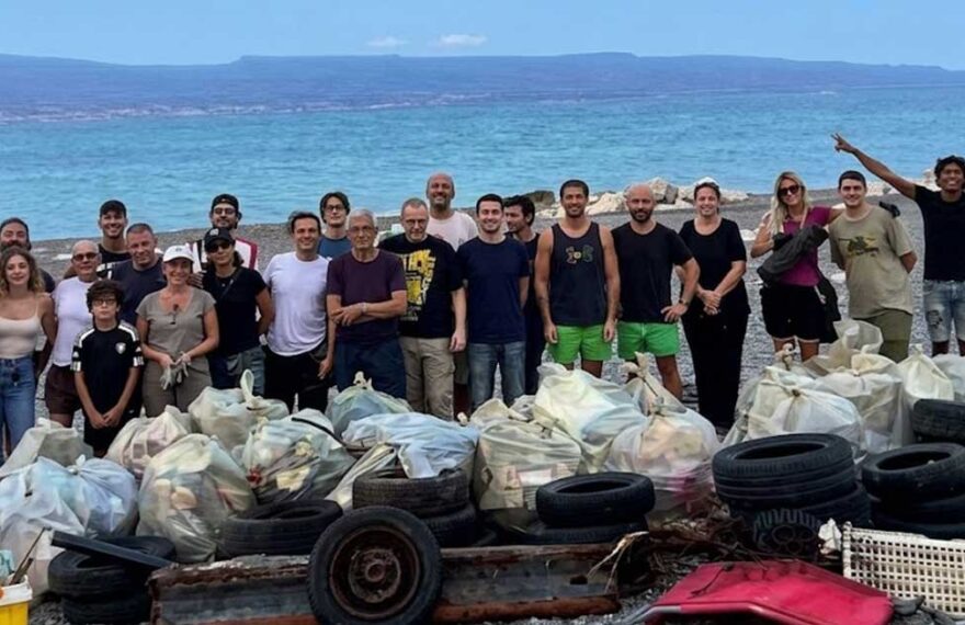 I volontari della pulizia spiagge a Messina in posa davanti ai sacchi di rifiuti e copertoni raccolti