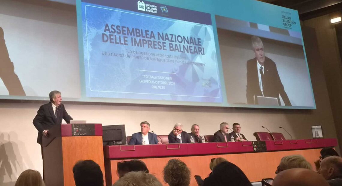 Assemblea Nazionale delle Imprese Balneari della fiera InOut a Rimini, con un grande schermo che proietta l'intervento e il titolo del dibattito sulle concessioni e il bando-tipo.