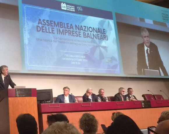 Assemblea Nazionale delle Imprese Balneari della fiera InOut a Rimini, con un grande schermo che proietta l'intervento e il titolo del dibattito sulle concessioni e il bando-tipo.