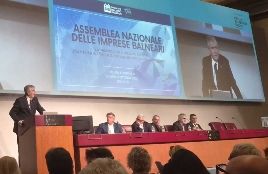 Assemblea Nazionale delle Imprese Balneari della fiera InOut a Rimini, con un grande schermo che proietta l'intervento e il titolo del dibattito sulle concessioni e il bando-tipo.