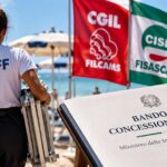 Lavoratrice in spiaggia con le bandiere dei sindacati Filcams, Fisascat e Uiltucs per il bando-tipo balneari