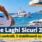 Militare della Guardia Costiera osserva il mare con binocolo e motovedetta in navigazione vicina agli ombrelloni