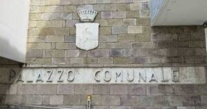 Facciata in pietra del Palazzo Comunale di Follonica con lo stemma del Comune.