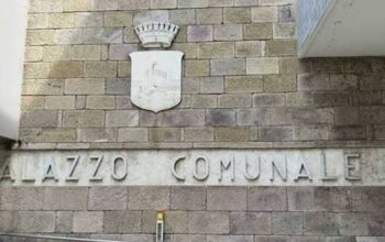 Facciata in pietra del Palazzo Comunale di Follonica con lo stemma del Comune.