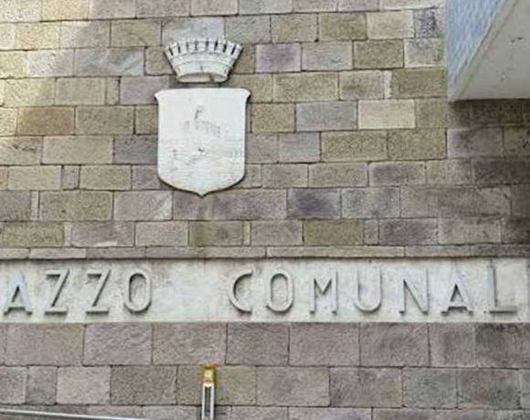 Facciata in pietra del Palazzo Comunale di Follonica con lo stemma del Comune.