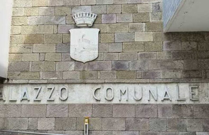 Facciata in pietra del Palazzo Comunale di Follonica con lo stemma del Comune.