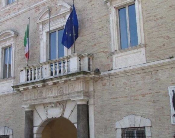 La facciata di Palazzo dei Priori, sede del Comune di Fermo, con le bandiere istituzionali