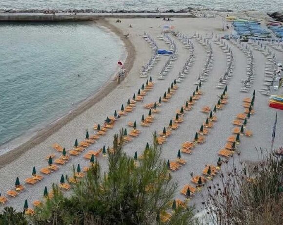 Vista dall'alto di una spiaggia attrezzata con ombrelloni ad Ancona sotto la falesia del Conero
