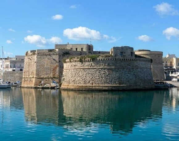 Vista del Castello Aragonese e del porto di Gallipoli riflessi sul mare azzurro