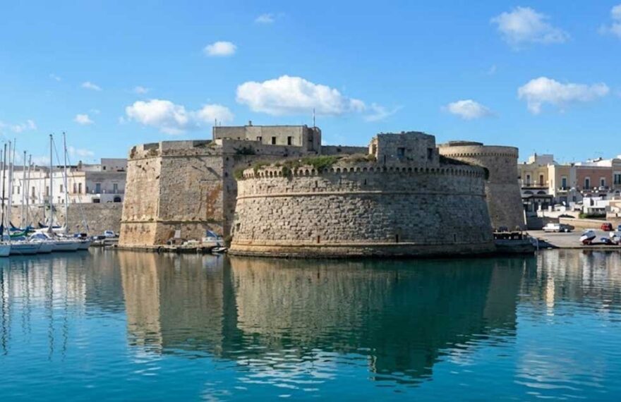 Vista del Castello Aragonese e del porto di Gallipoli riflessi sul mare azzurro