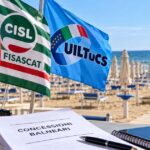 Bandiere sindacali di Filcams Cgil, Fisascat Cisl e Uiltucs in spiaggia con documento su gare balneari Comacchio.