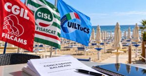 Bandiere sindacali di Filcams Cgil, Fisascat Cisl e Uiltucs in spiaggia con documento su gare balneari Comacchio.