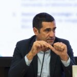 Il presidente della Regione Emilia-Romagna Michele De Pascale durante un intervento pubblico con il logo RER sullo sfondo