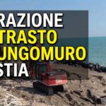 Demolizioni e rimozione del lungomuro a Ostia con ruspa in azione e testo sovrimpresso: "Operazione contrasto al lungomuro di Ostia"