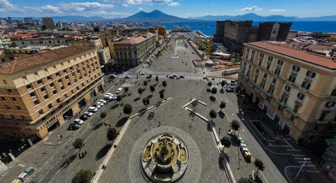 Veduta dall'alto di Piazza Municipio a Napoli con Castel Nuovo e il Vesuvio sullo sfondo