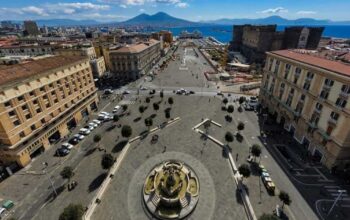 Veduta dall'alto di Piazza Municipio a Napoli con Castel Nuovo e il Vesuvio sullo sfondo