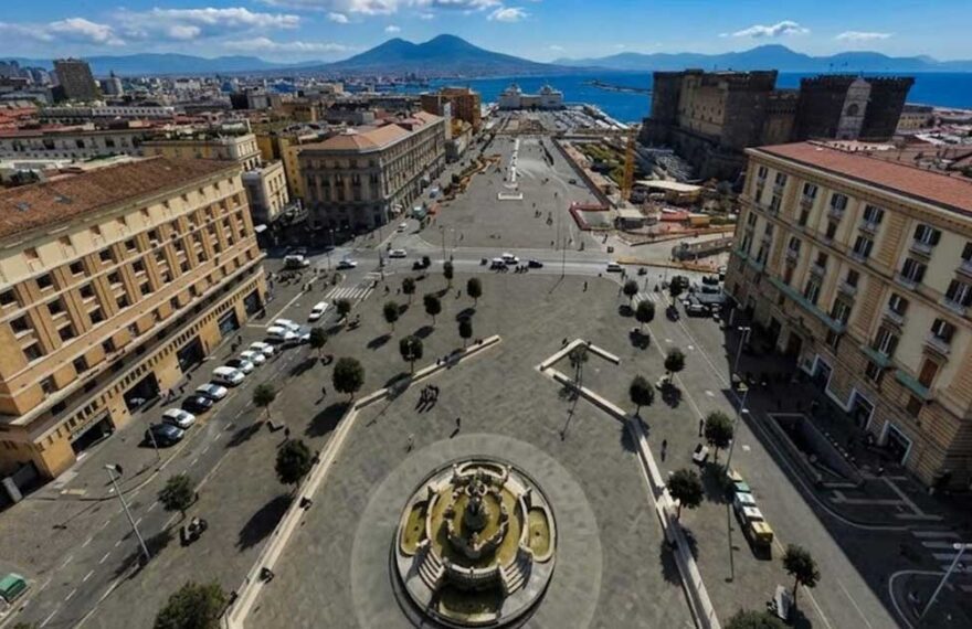 Veduta dall'alto di Piazza Municipio a Napoli con Castel Nuovo e il Vesuvio sullo sfondo