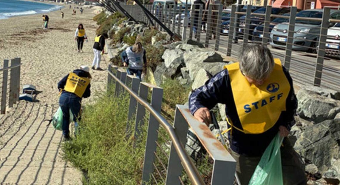 Volontari in gilet giallo impegnati nella pulizia dei rifiuti lungo la passeggiata e la spiaggia di Savona.