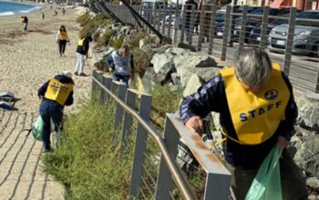 Volontari in gilet giallo impegnati nella pulizia dei rifiuti lungo la passeggiata e la spiaggia di Savona.