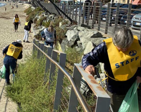 Volontari in gilet giallo impegnati nella pulizia dei rifiuti lungo la passeggiata e la spiaggia di Savona.