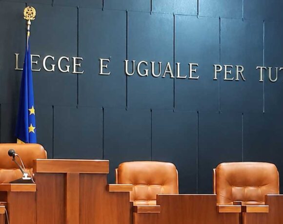 Aula di tribunale italiana vuota con il banco dei giudici e la scritta La legge è uguale per tutti