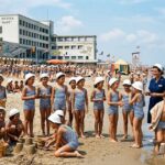 Bambini in costume da bagno giocano sulla spiaggia davanti all'edificio della colonia marina Sole e Mare