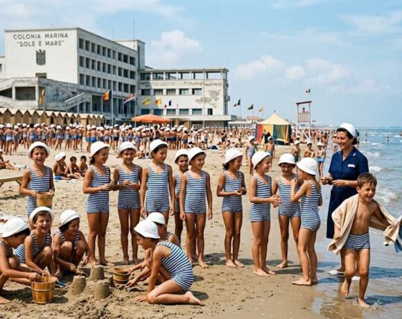 Bambini in costume da bagno giocano sulla spiaggia davanti all'edificio della colonia marina Sole e Mare