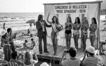 Fotografia d'epoca in bianco e nero con le concorrenti del concorso Miss Spiaggia 1974 sulla sabbia