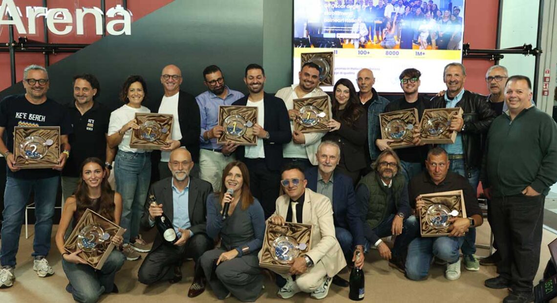 Foto di gruppo dei vincitori del concorso Best Beach 2026 con i trofei alla fiera InOut di Rimini